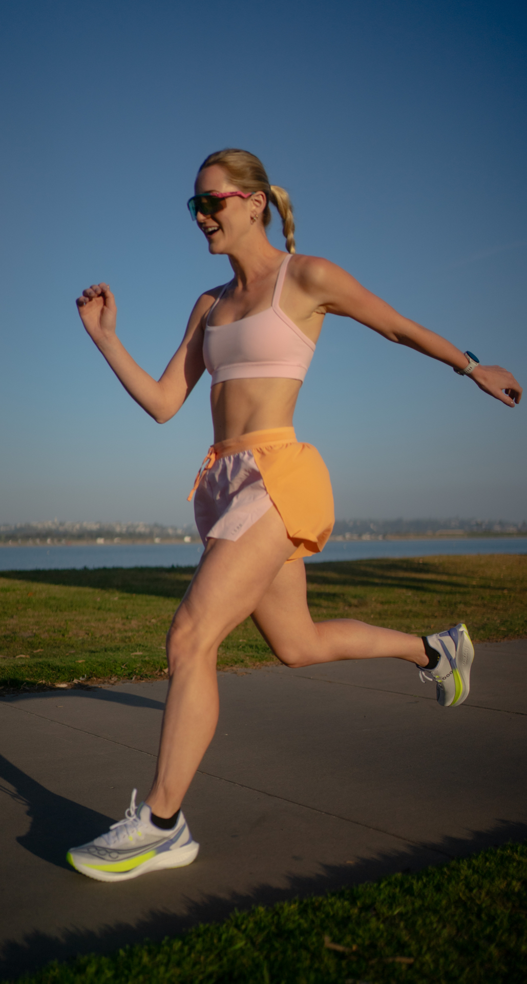 Coach mid-stride on a morning run by the bay